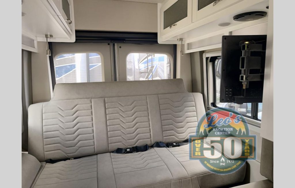 Coachmen RV Beyond 22C AWD motorhome interior with sofa in the rear and a TV mounted on the wall